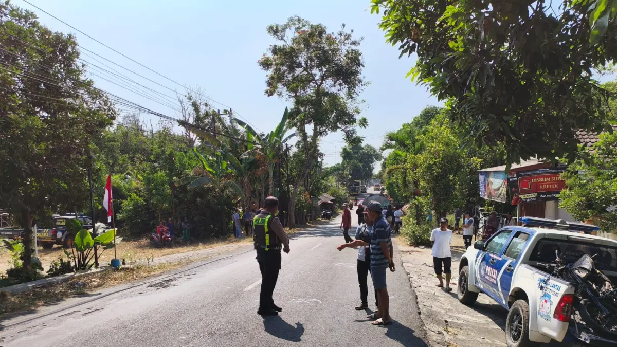 Polisi mengamankan lokasi kejadian kecelakaan yang melibatkan truk, pikap, dan motor di Desa Cepoko, Kecamatan Berbek. 