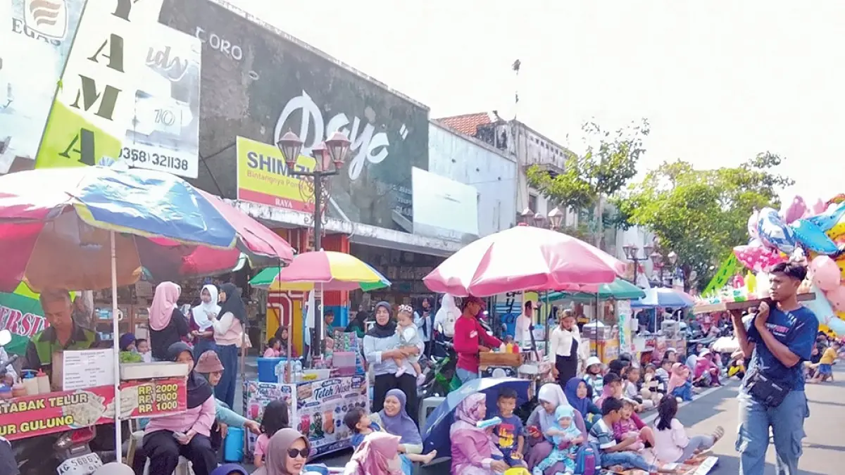 PANAS SIANG HARI: Bupati Marhaen Djumadi dampingi Seka Nur Solekan dan Ketua PHBN Nganjuk Puguh Harnoto memberangkatkan karnaval SD dan MI Kecamatan Nganjuk kemarin. Ribuan penonton karnaval berteduh dan memakai payung di sepanjang jalan Ahmad Yani Nganjuk. (karen wibi/jprk)