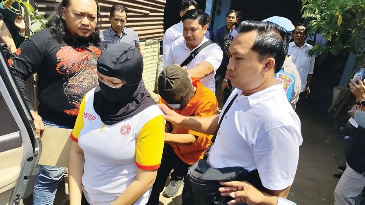 DURHAKA: Diana Marcelynda Gatot dan Novian Jery Saputra, pacarnya dikawal ketat polisi saat rekonstruksi pembunuhan Gatot  Tri Wahyu Widodo, ayah angkat Diana kemarin. Warga mancaci maki tersangka. (novanda nirwana/jprk)