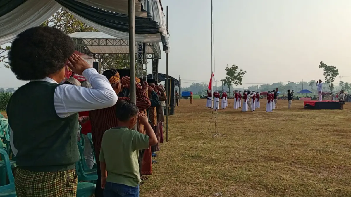 Peserta upacara HUT RI di Lapangan Desa Banjaranyar, Kecamatan Tanjunganom, Kabupaten Nganjuk memberikan hormat saat pengibaran bendera Merah putih yang dipimpin Kades Banjaranyar Samsul Anam.