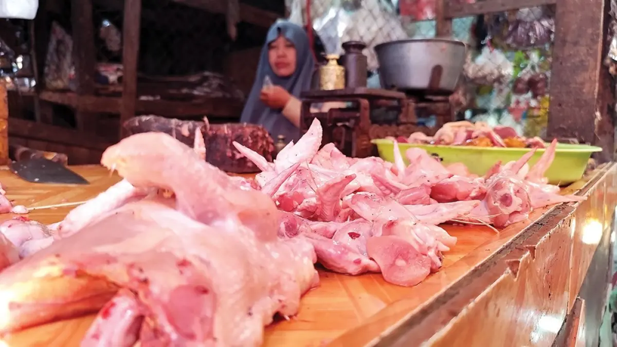 MELONJAK: Pedagang ayam di Pasar Wage Nganjuk menunggu pembeli. Harga ayam menembus Rp 40 ribu per kilogram kemarin. (novanda nirwana/jprk).