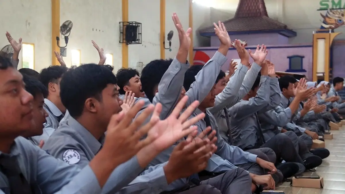 SMASA MENYALA: Kepala SMA Negeri 1 Nganjuk Sugiyono,Manajer Digital dan Online Jawa Pos Radar Kediri Anwar Bahar Basmalah,dan perwakilan AXIS foto bersama ratusan siswa di Aula Smasa kemarin. Siswa Smasa antusias (foto kiri). (karen wibi/jprk).
