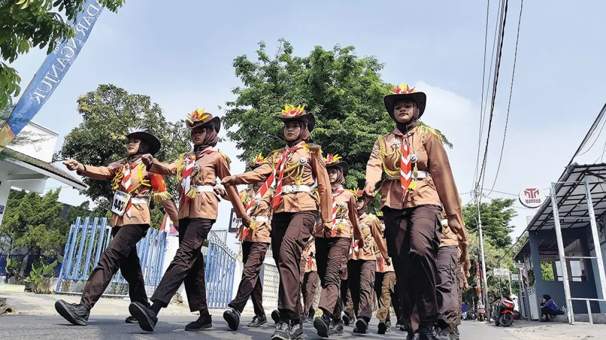 PIKAT PENONTON: Peserta gerak jalan tingkat SMA/SMK melintas di depan Kantor Jawa Pos Radar Nganjuk kemarin. (novanda nirwana/jprk)
