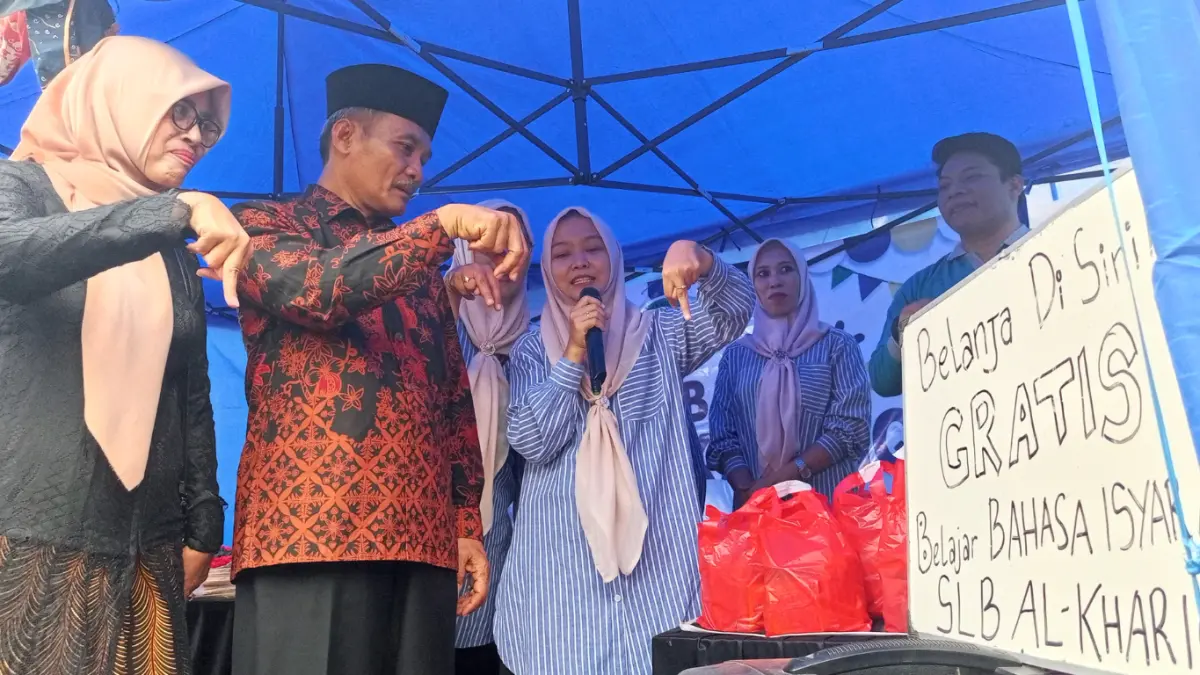 Ainun, Guru SLB Al Khari memeragakan bahasa isyarat kepada Camat Ngronggot Mohamad Makrup dan istrinya. 