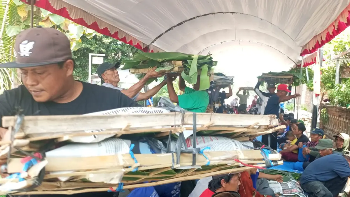 Panitia membagikan lecek kepada Warga Dusun Sumberwaru sebelum doa bersama. 