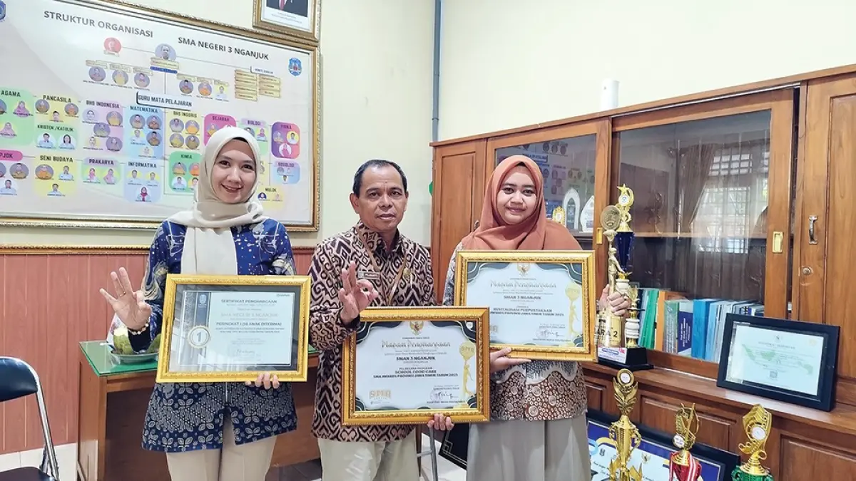 BERPRESTASI: Kepala SMAN 3 Nganjuk Pujianto (tengah) menunjukkan Piagam dan Piala yang diraih sekolahnya. (novanda nirwana/jprk)