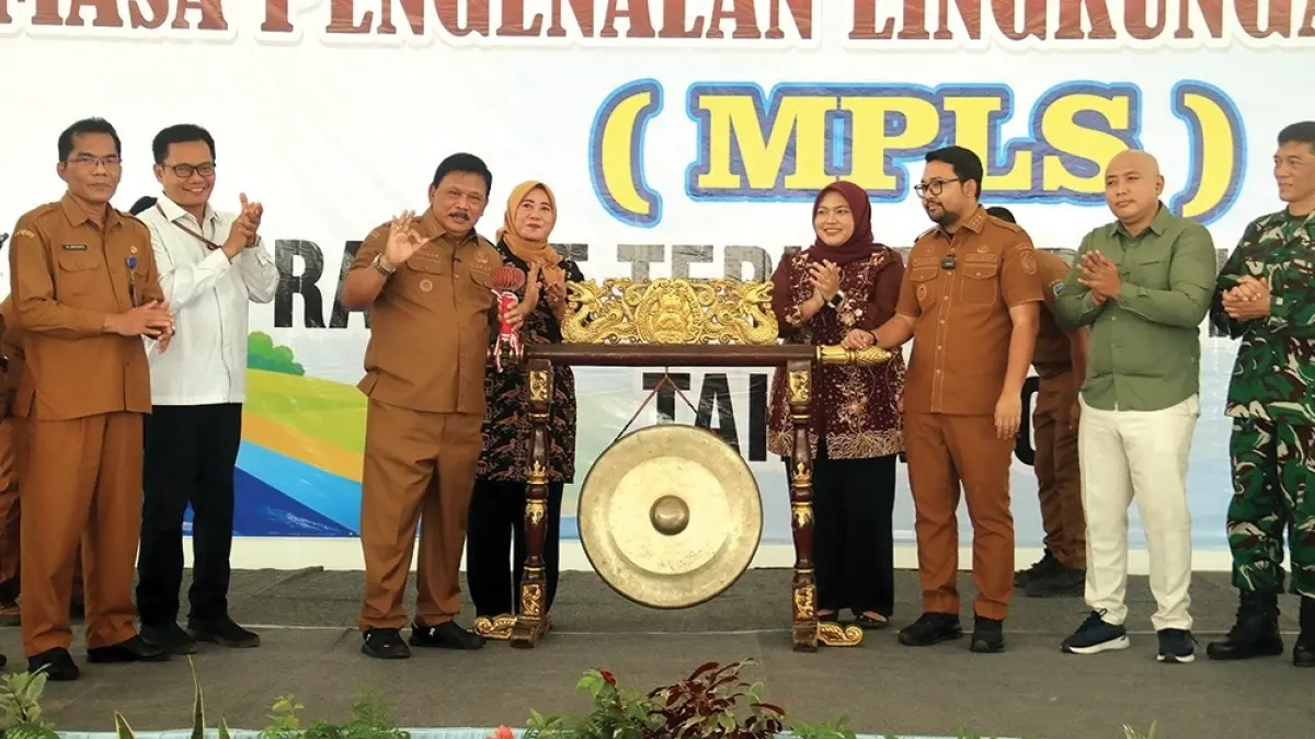 BERSEDIH: Putri Aprilia menggendong adiknya sambil meneteskan air mata kemarin. Siswa Sekolah Rakyat Nganjuk harus masuk asrama di hari pertama masa pengenalan lingkungan sekolah (MPS). (karen wibi/jprk)