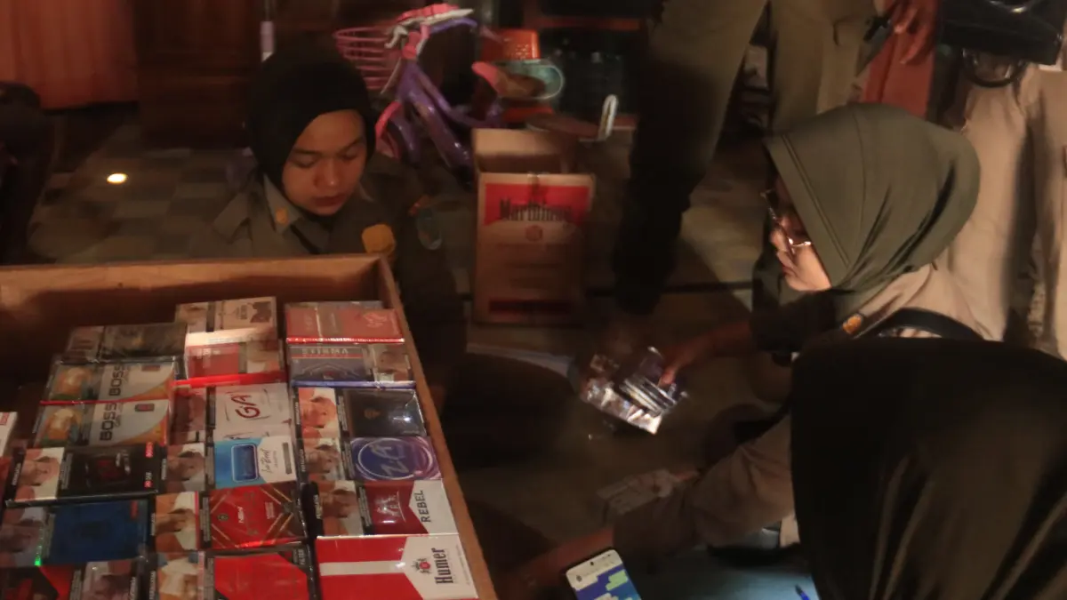 Petugas gabungan Satpol PP dan Bea Cukai melakukan razia di salah satu toko penjualan rokok di Kabupaten Nganjuk. 