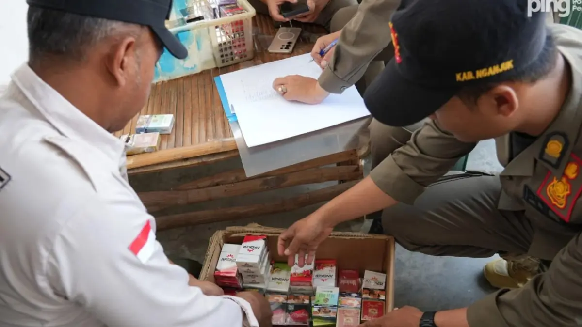 Petugas Satpol PP dan Bea Cukai Kediri melakukan penyitaan rokok ilegal yang disimpan di dalam kardus. 