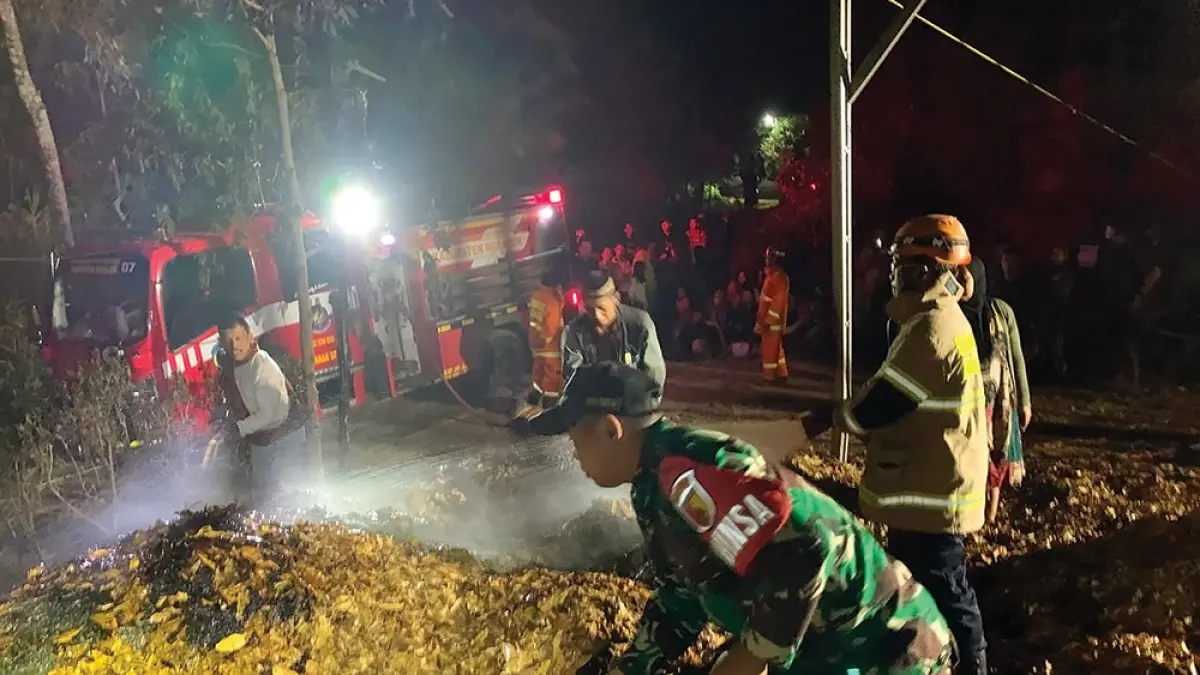 ASAP MENGEPUL: Babinsa dan warga membantu petugas damkarmat memadamkan api yang melalap sulingan cengkih. (novanda nirwana/jprk)