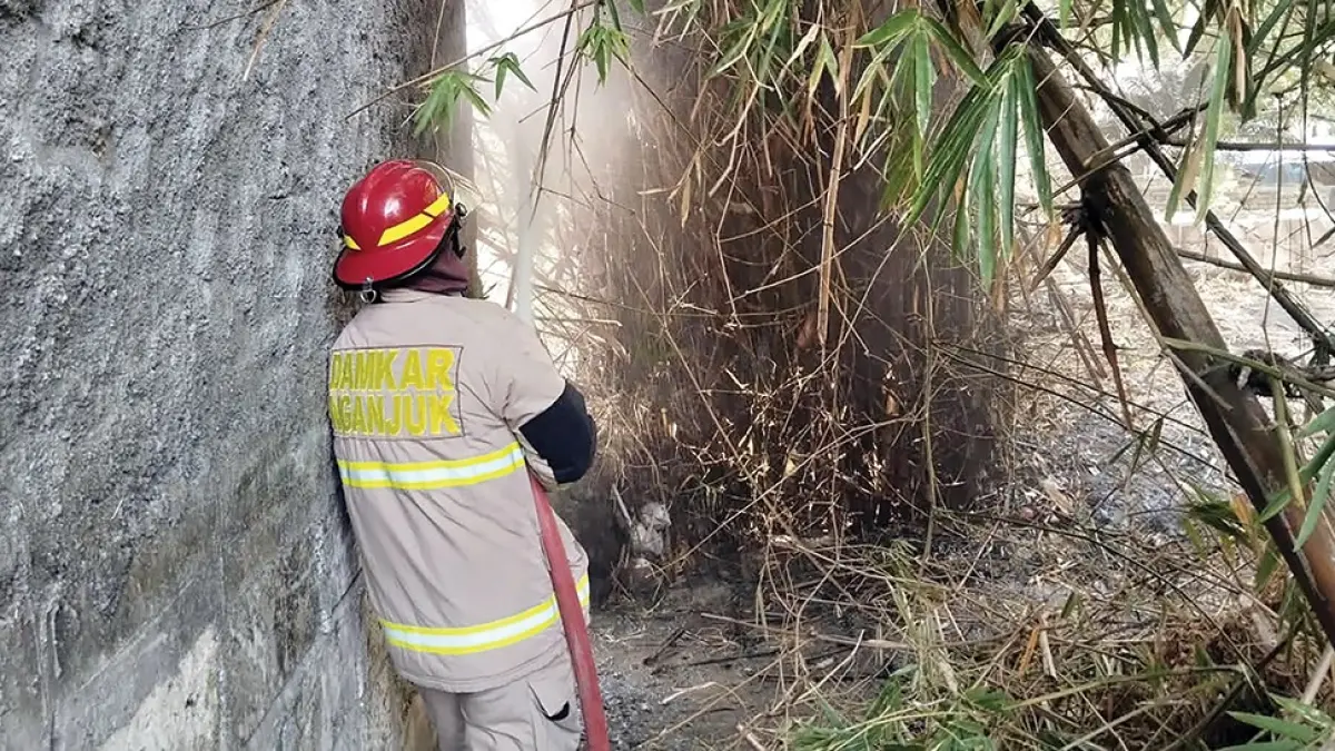 GEMPAR: Petugas Damkarmat Nganjuk memadamkan si jago merah yang melalap rumbun bambu di Desa Duwei, Rejoso. (novanda nirwana/jprk),