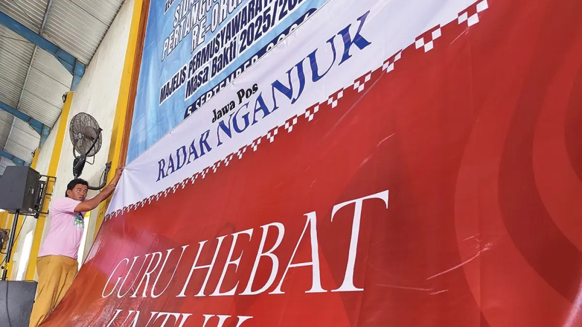 PERSIAPAN: Panitia Guru Hebat untuk Nganjuk Melesat memasang banner di SMA Negeri 1 Nganjuk kemarin. (novanda nirwana/jprk)