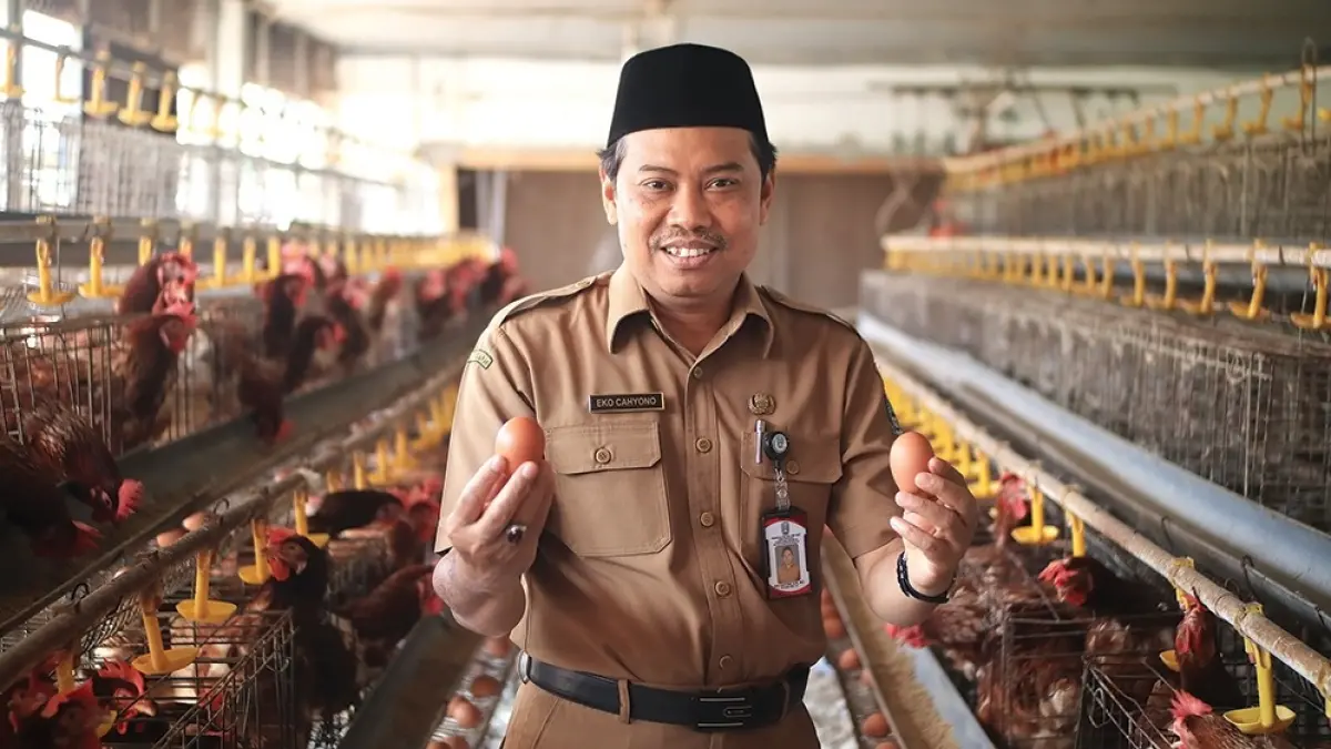 INOVATIF: Kepala SMKN 1 Gondang Eko Cahyo di kandang ayam petelur sekolahanya. (karen wibi/jprk)
