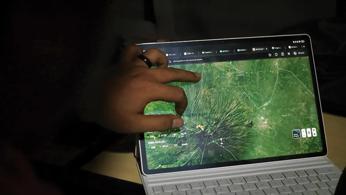 PANTAU TITIK API: Petugas mengamati kondisi puncak Gunung Wilis lewat laptop. Kebakaran susulan masih mengancam. (karen wibi/jprk).