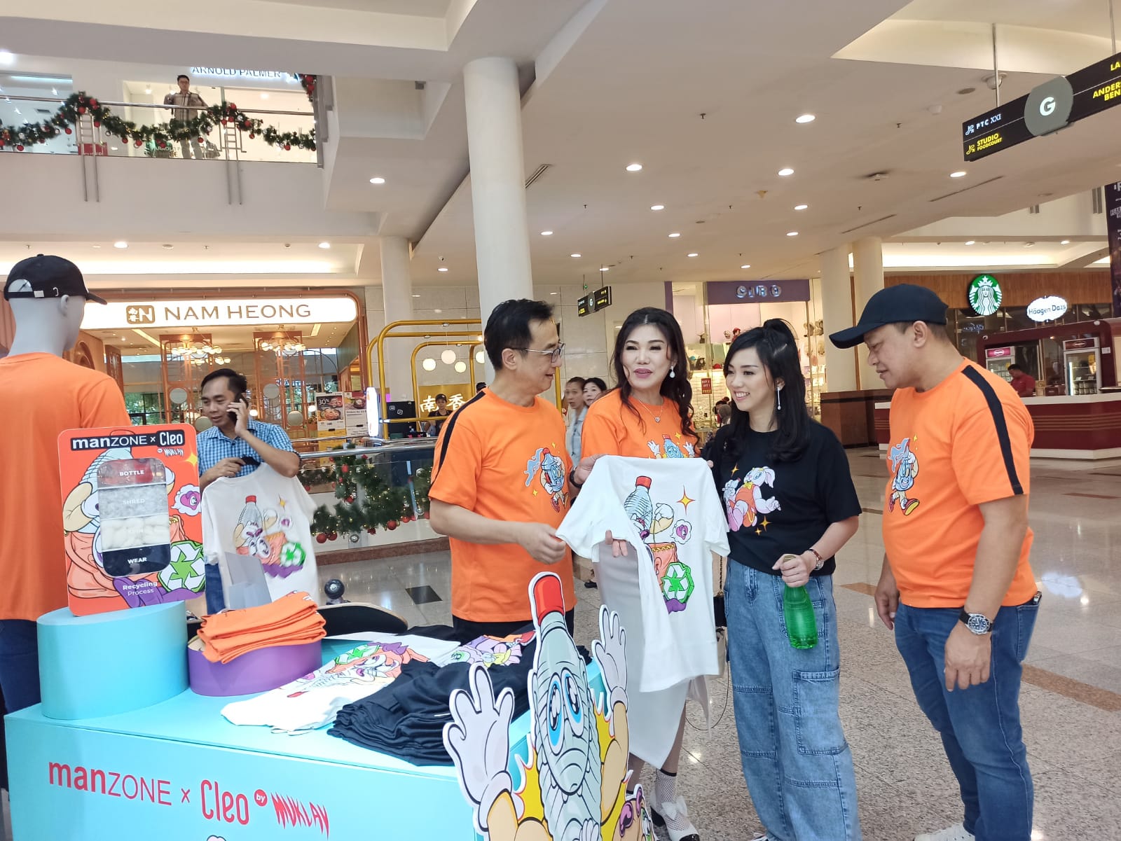 GREEN FASHION: Hermanto Tanoko (kiri) dan Melisa Patricia (dua dari kanan) menunjukan kaos Manzone berbahan plastik daur ulang yang mulai dipasarkan di Surabaya.