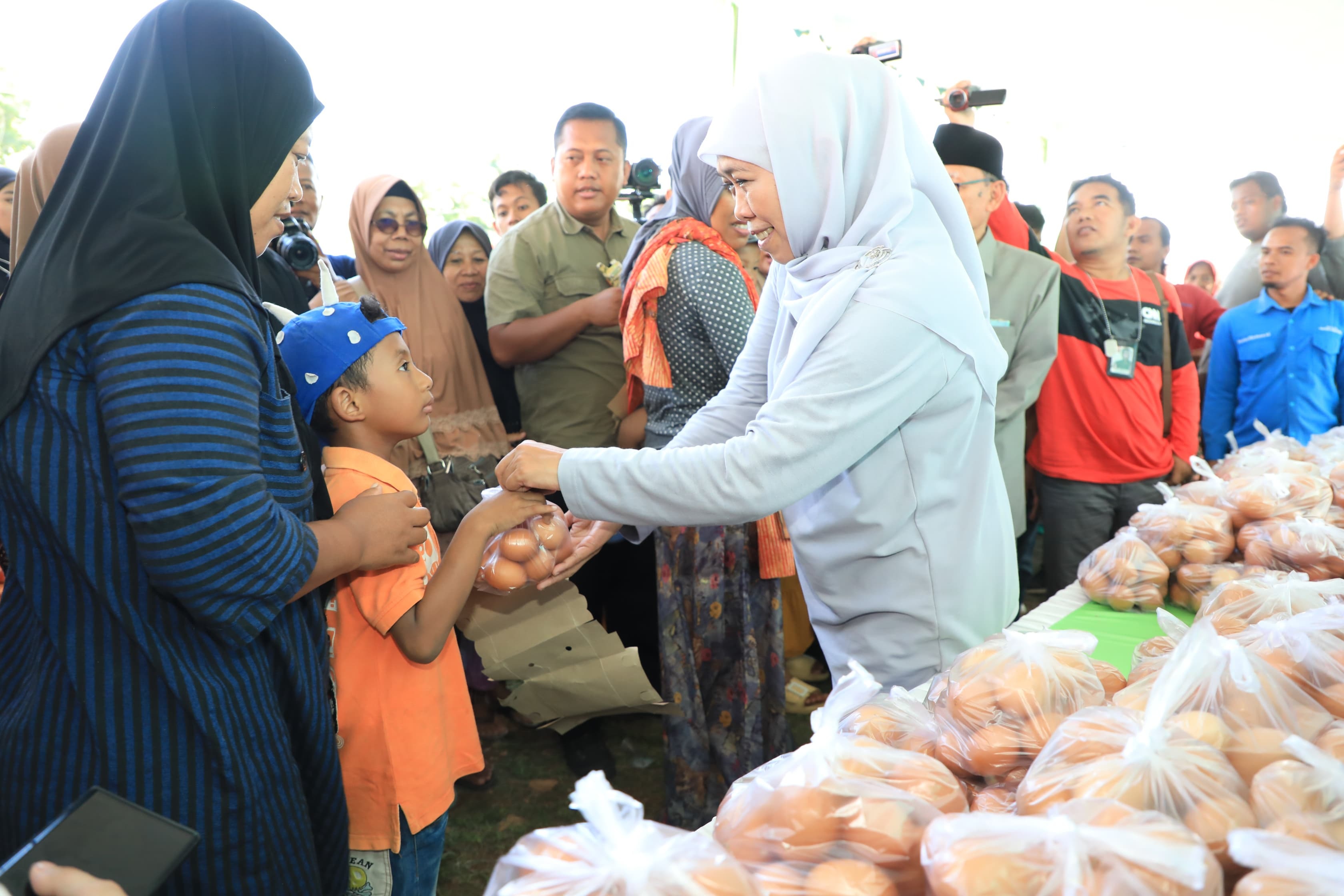 MENATAP SAYANG: Gubernur Khofifah menyerahkan bantuan bahan makanan berupa telur ayam untuk calon generasi emas, anak-anak, di Jawa Timur.