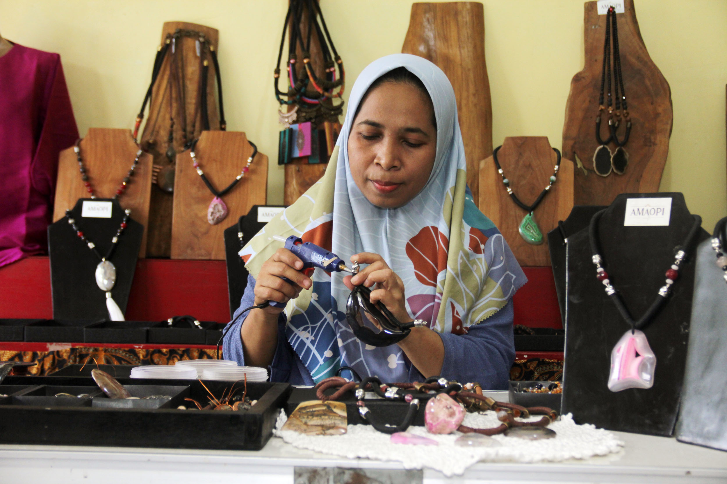 INDAH: Acik Yuli Triasasi, perajin batu alam di kawasan Raya Wonorejo, Surabaya, membuat aksesoris yang dijual pada turis asing hingga keluar negeri.