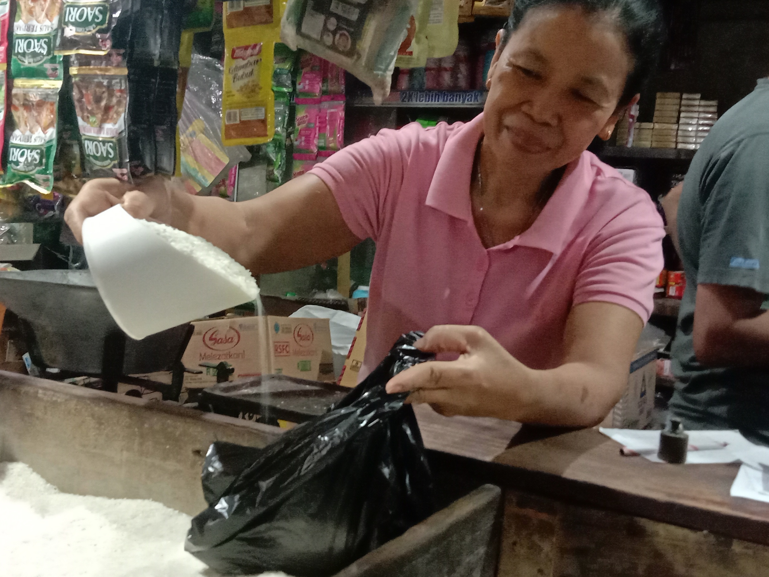 MEROKET: Pedagang beras di Pasar Dukuh Kupang, Surabaya terlihat hendak meladeni pembelian beras ditengah mahalnya harga beras.