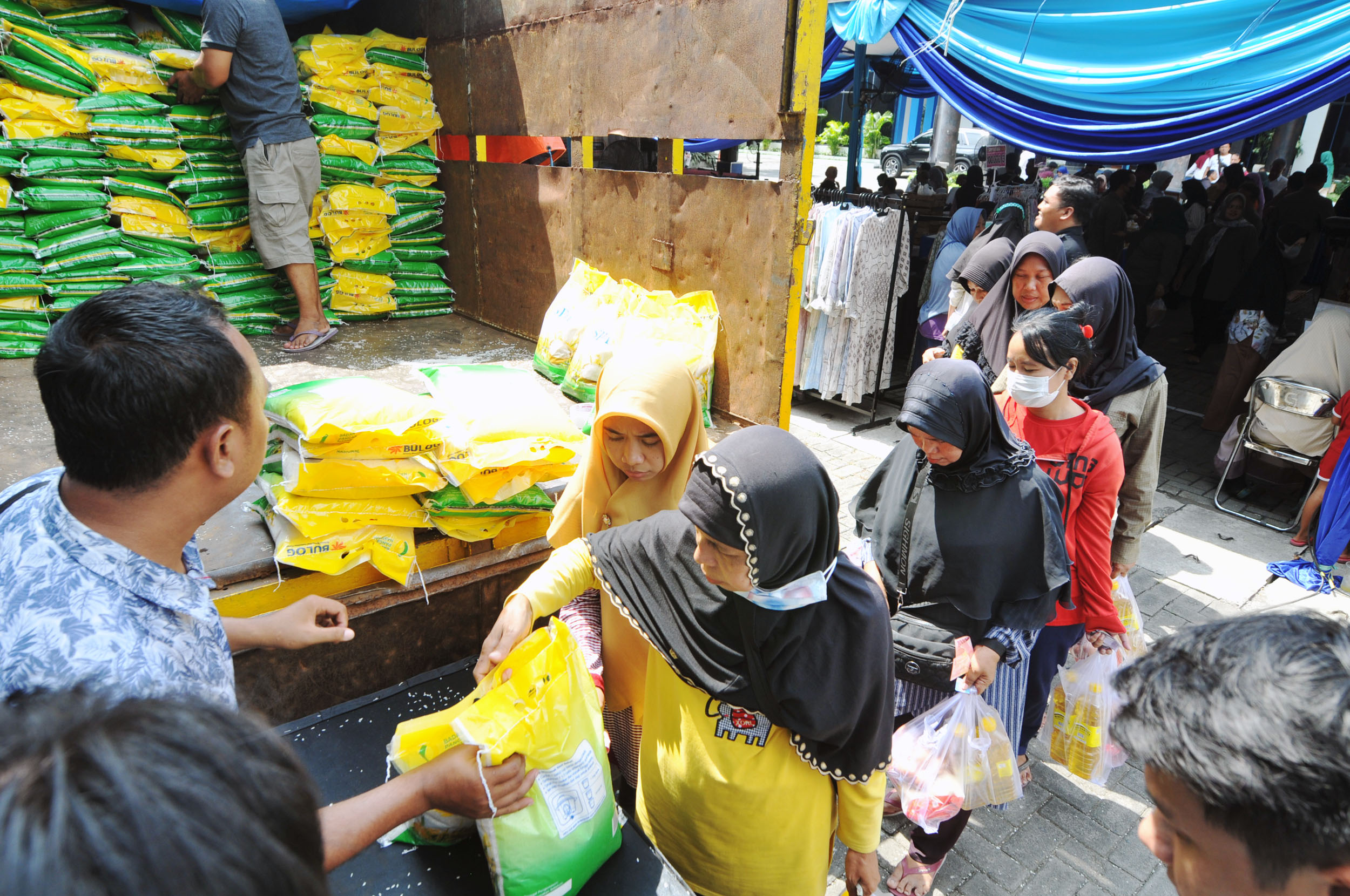Warga mengantre membeli beras di Pasar Murah yang diadakan Pemprov Jatim.