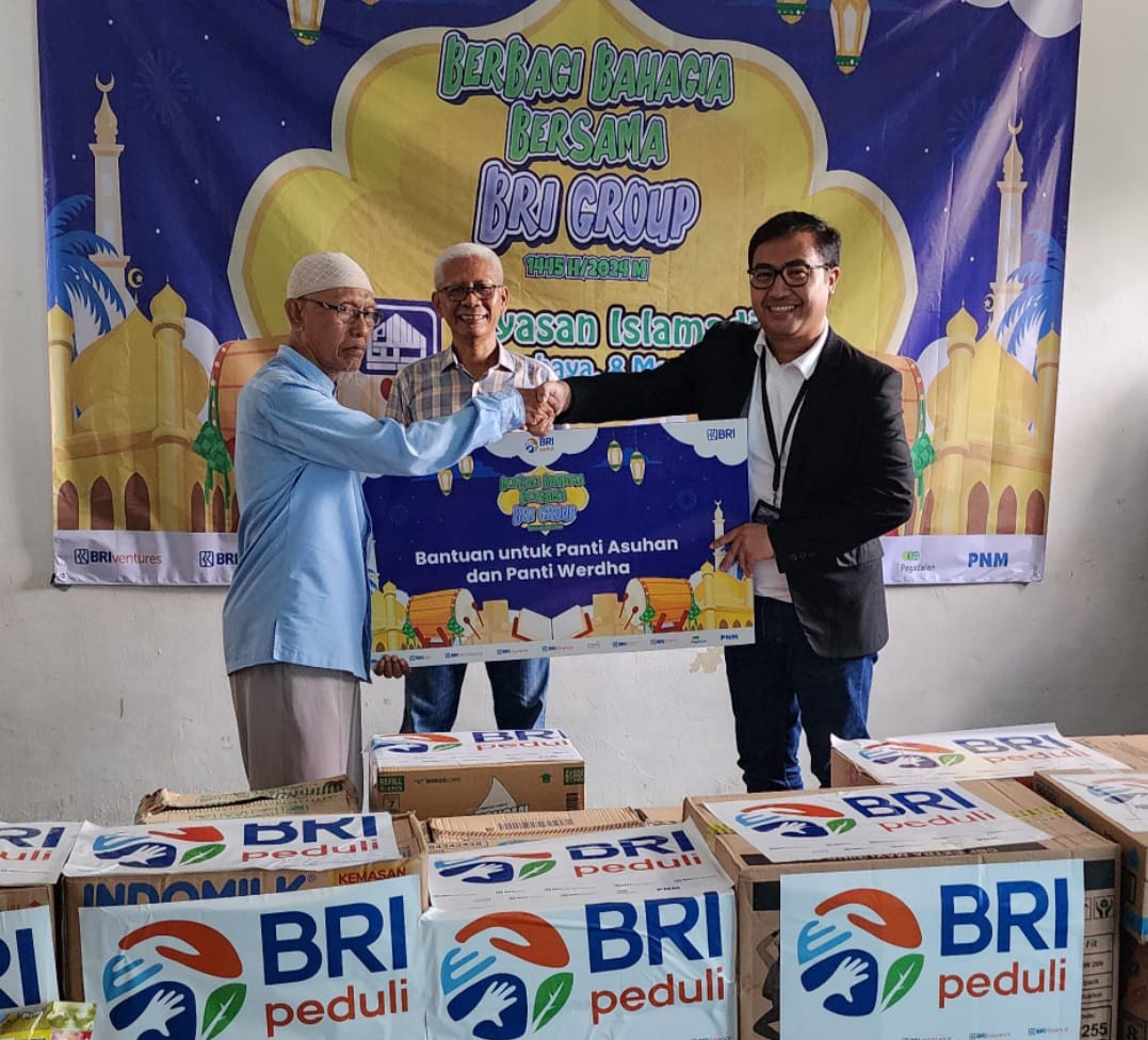 Pemimpin Cabang BRI Branch Office Surabaya Manukan, Adi Nugroho (kanan) secara simbolis memberikan bantuan paket sembako kepada Panti Asuhan Yayasan Islamadina di daerah Benowo, Surabaya, Jumat (8/3).