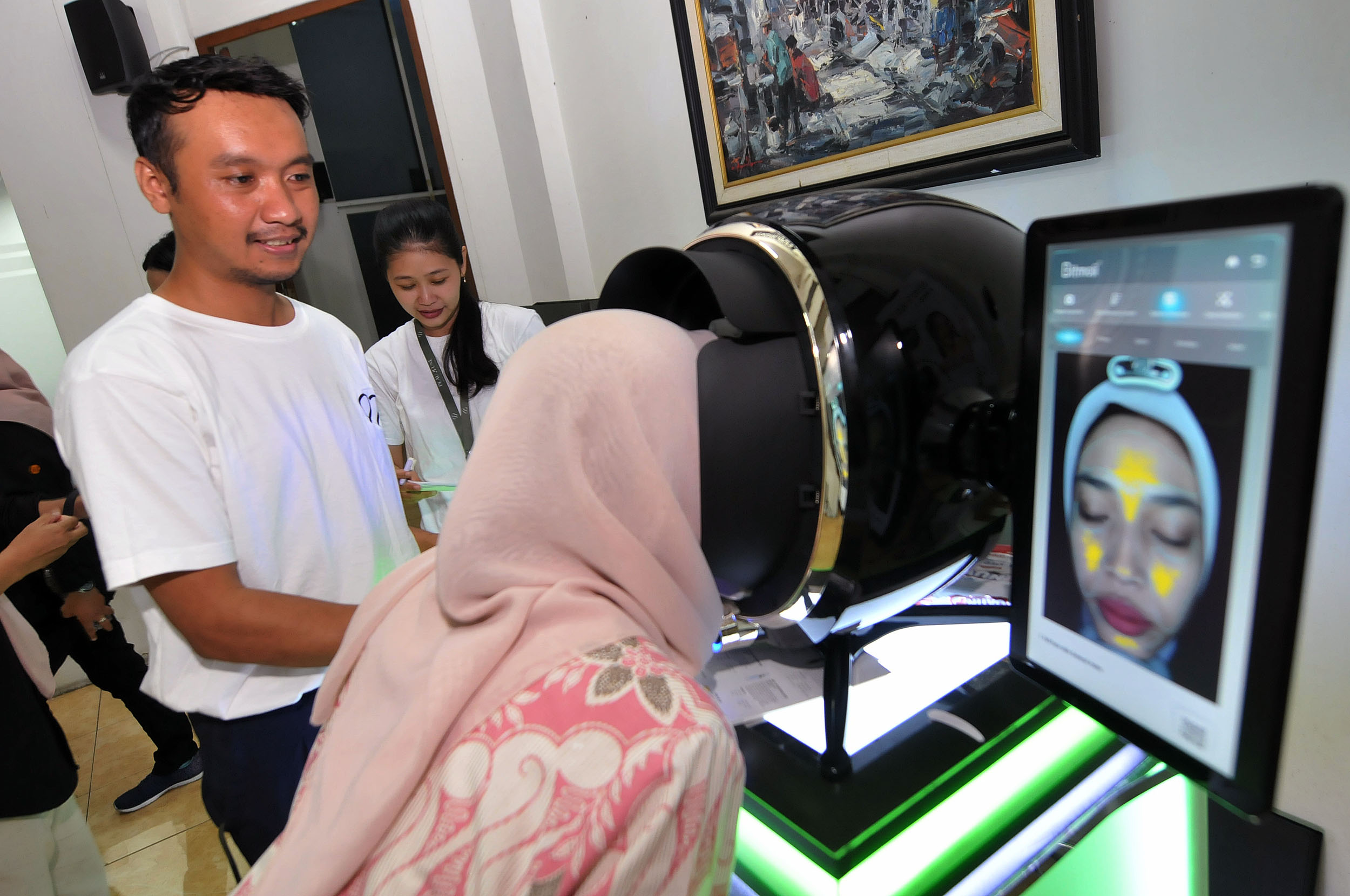 PERAWATAN WAJAH: Pegawai Radar Surabaya memeriksa kondisi kulit wajahnya melalui skin analyzer pada kegiatan Buka Bersama Yamaha STSJ di kantor Radar Surabaya, Rabu (20/3).