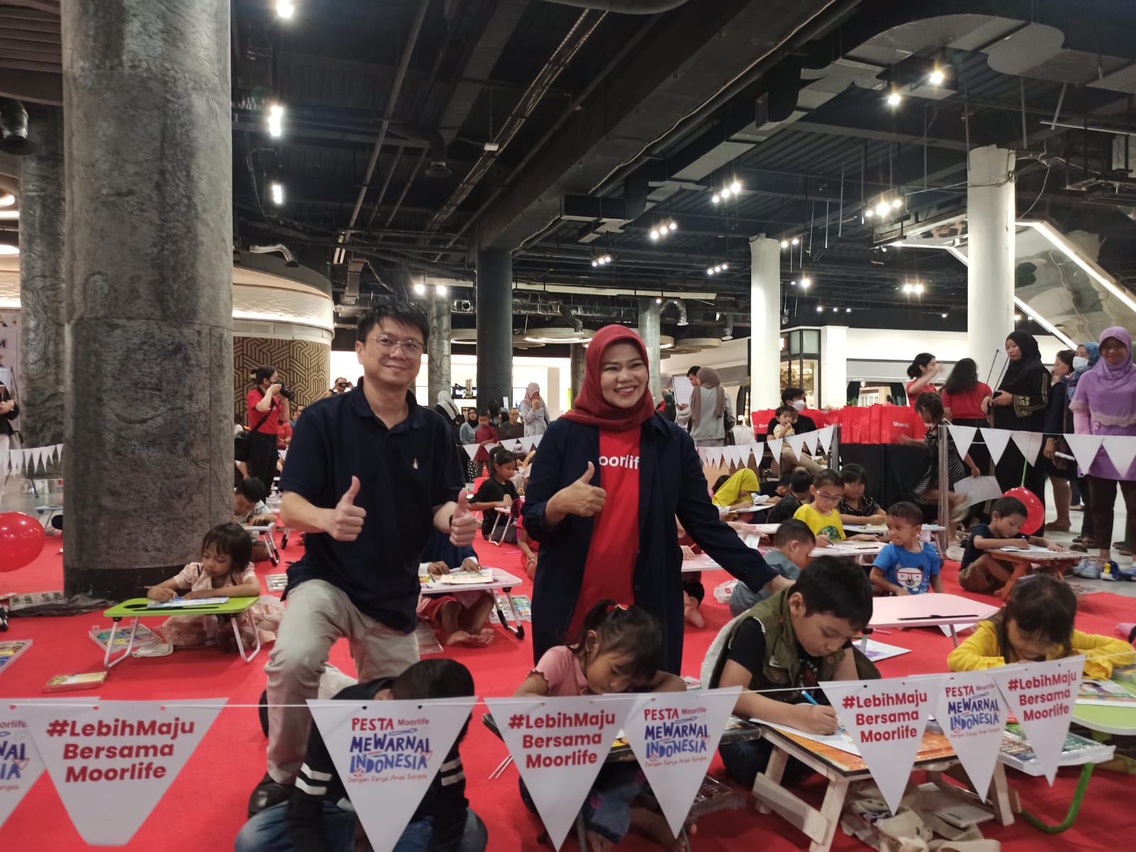 Adi suhono dan Nurlailan Hidayaty saat melihat anak-anak mewarnai dalam acara Pesta Moorlife Mewarnai Indonesia di Ciputra World Surabaya.