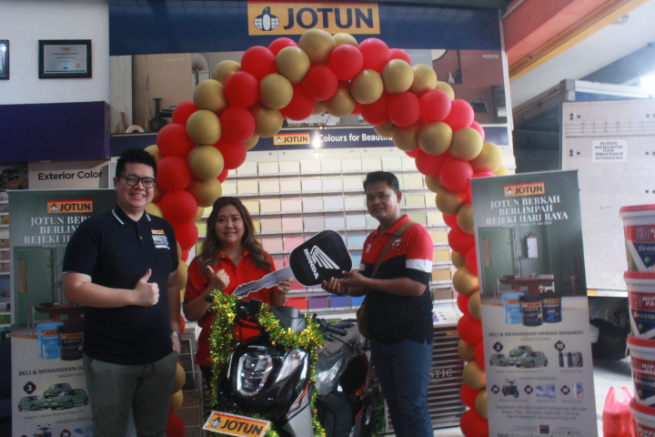 Stevan Suryanto (kiri) secara simbolis menyerahkan hadiah sepeda motor Honda Genio pada Sholihan, pelanggan toko bangunan Artha Kencana Surabaya yang beruntung.