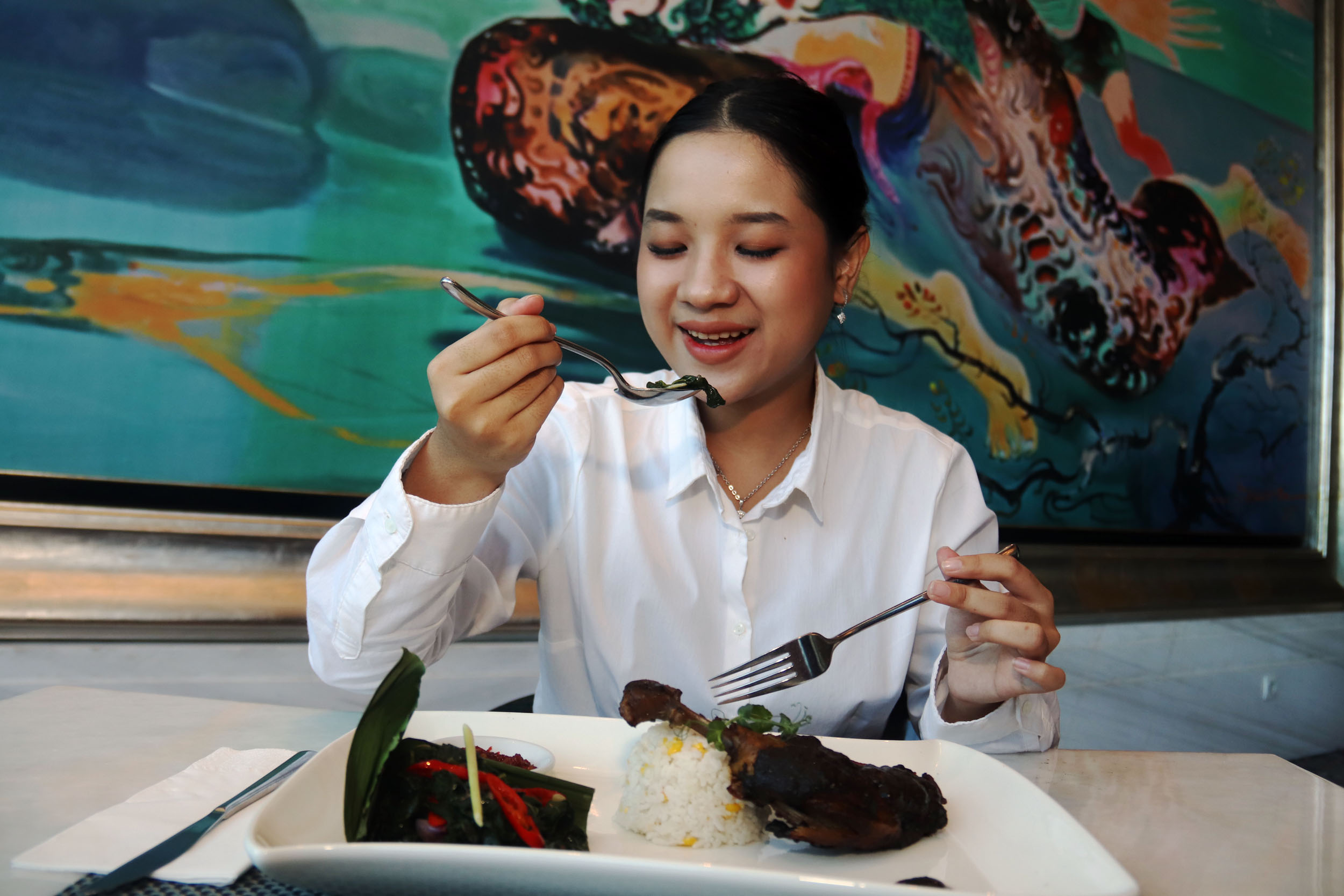 OTENTIK: Kaylee Melino menyantap sajian Bebek Hitam yang menggunakan bumbu rawon di Ciputra World Hotel Surabaya, Rabu (15/5).