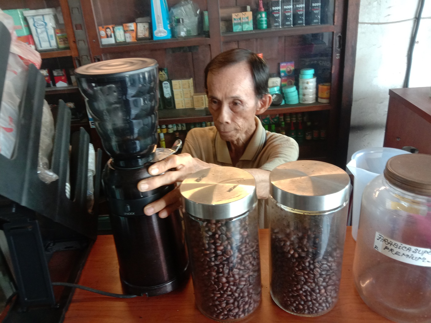 GENERASI KETIGA: Gunawan sedang menggiling biji kopi untuk membuatkan pesanan pelanggan.