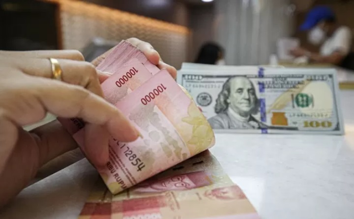 BERHITUNG: Seorang karyawan di bisnis penukaran asing sedang menghitung rupiah yang akan dibelikan dollar Amerika Serikat. (JAWA POS)