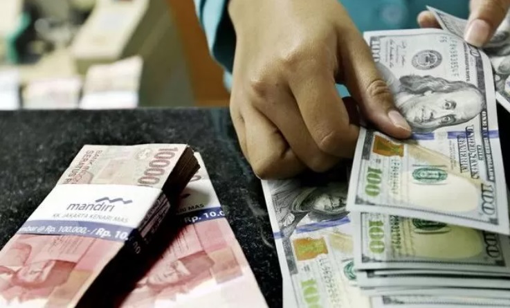 BERHITUNG: Seorang karyawan di bisnis penukaran asing sedang menghitung rupiah yang akan dibelikan dollar Amerika Serikat. (JAWA POS)