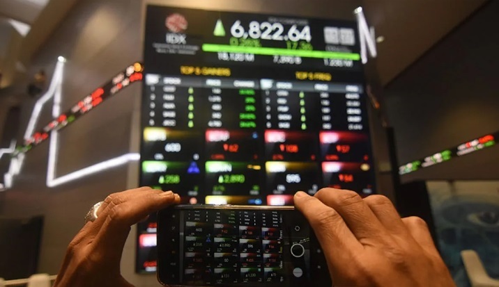 ILUSTRASI: seorang pialang mengabadikan pergerakan Indeks Harga Saham Gabungan (IHSG) di Bursa Efek Indonesia.