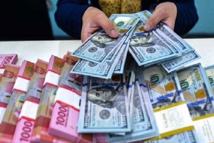 TUKAR: Mata uang rupiah dan dolar Amerika Serikat saling dipertukarkan.