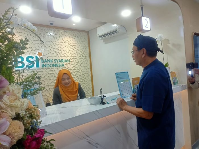 SAPA: Rektor Universitas Airlangga M Nasih berbincang dengan teller BSI di kantor cabang pembantu BSI Unair, Selasa (29/10).
