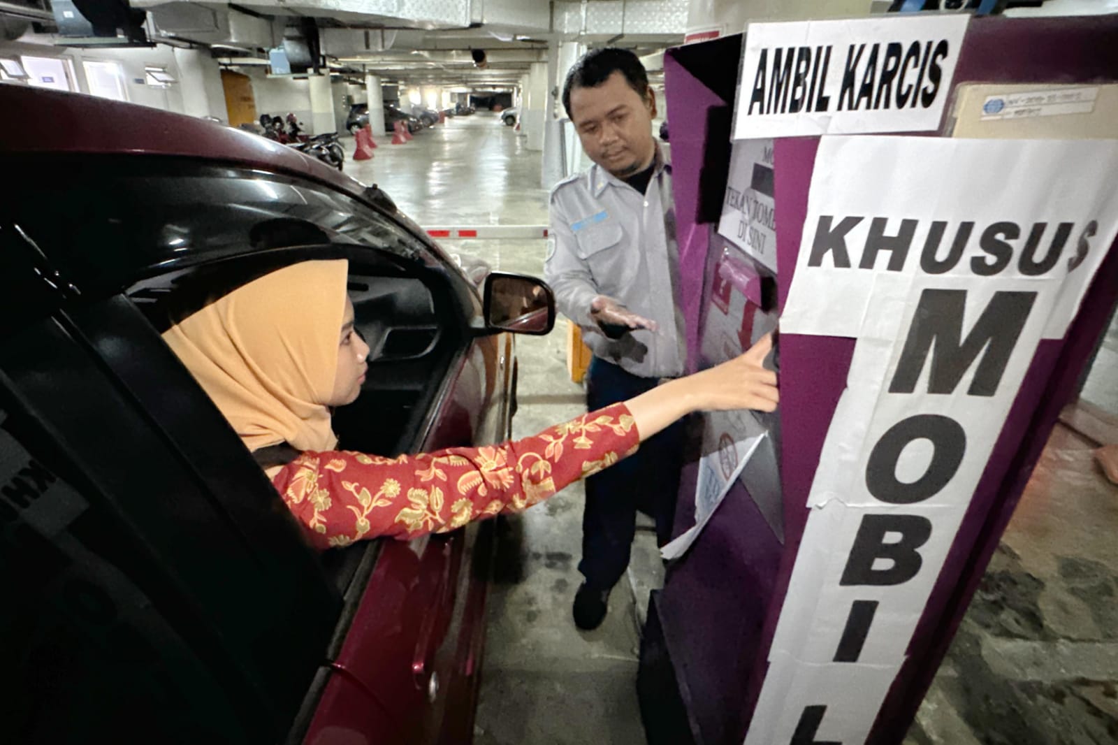 BAYAR: Pengunjung melakukan pembayaran retribusi parkir secara nontunai di area Alun-Alun Surabaya, Jalan Yos Sudarso, Surabaya.