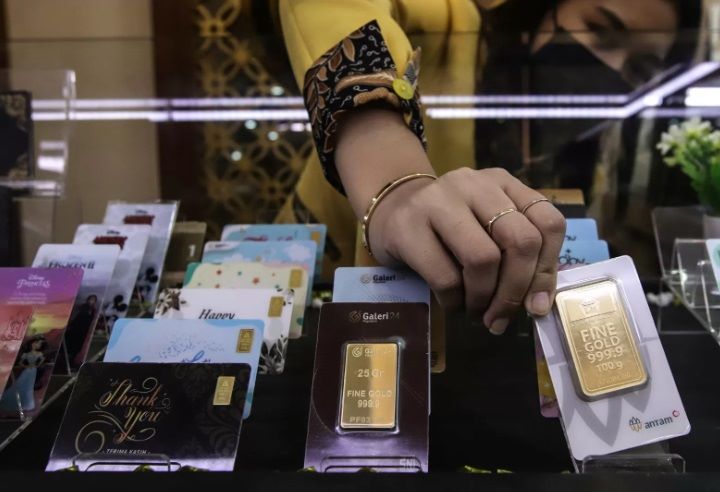 PILIH: Karyawan butik ANtam menunjukkan salah satu koleksi emas batangannya.