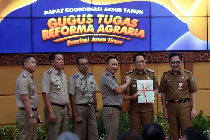 TERIMA SERTIFIKAT: Pj Gubernur Jatim Adhy Karyono menerima sertifikat dari ATR BPN setelah pembukaan Rapat Koordinasi Gugus Tugas Reforma Agraria Jatim, di gedung Setdaprov  Jatim, Senin (18/11).