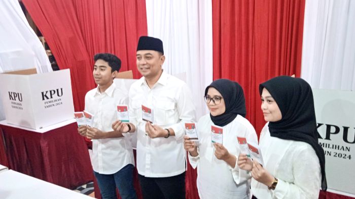 DEMOKRASI: Eri Cahyadi bersama keluarga usai memberikan hak suaranya di TPS 4 Ketintang Permai Karah Surabaya.