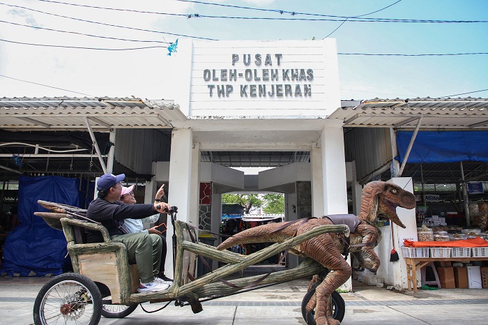 JALAN-JALAN: Pengunjung menikmati wahana baru yaitu Dino Dokar di THP Kenjeran, Surabaya.