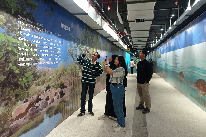 FOTO DULU: Sejumlah pengunjung KBS merekam gambar-gambar video mapping indah di sepanjang terowongan penghubung TIJ-KBS usai diresmikan Wali Kota Eri Cahyadi Surabaya, Senin (23/12/2024).