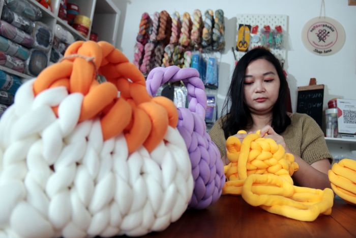 TAS RAJUT: Perajin rajut, Julanita Linasari menunjukkan proses pembuatan Chunky bag, di workshopnya Autumn Flower kawasan Prapen, Surabaya, Rabu (25/12/2024).