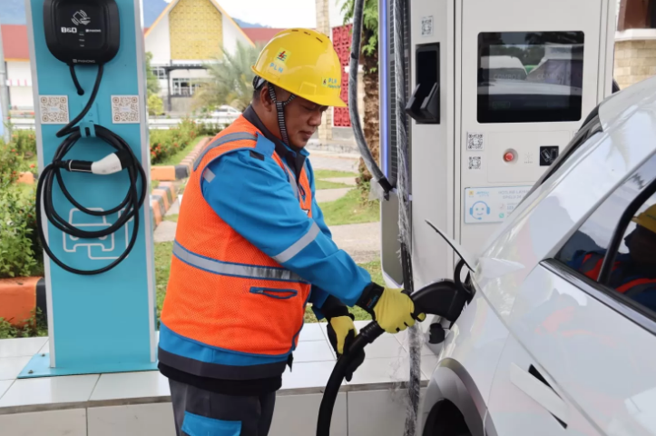 ISI: Petugas PLN membantu pengguna kendaraan listrik melakukan pengisian daya di SPKLU Rest Area Jalan Tol Trans Sumatera.