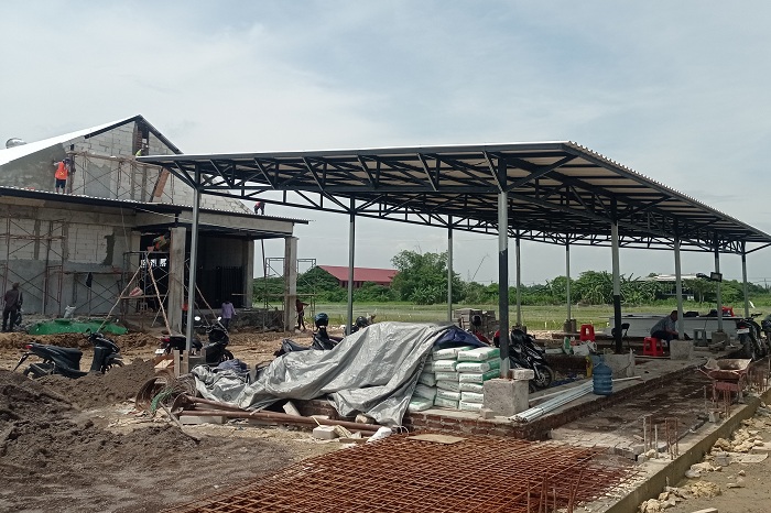 DIKEBUT: Pekerja menyelesaikan pembangunan rumah potong unggas di kawasan Jeruk, Lakarsantri, Surabaya.