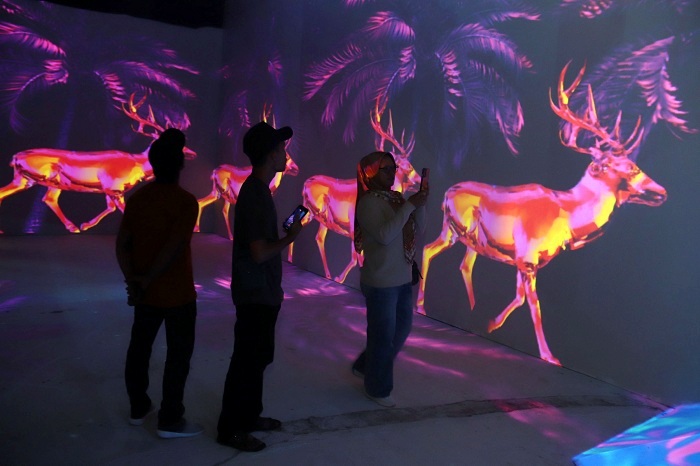 WAHANA BARU: Sejumlah pengunjung menikmati pertunjukan metaverse flora dan fauna di wahana baru Glow Interactive Park, yang merupakan bagian Kebun Binatang Surabaya (KBS), Kamis (26/12/2024).