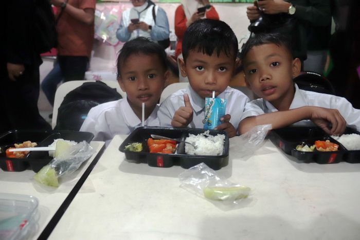 MINUM SUSU: Tiga siswa SD di Surabaya tertawa bahagia setelah menyantap menu program Makan Bergizi Gratis (MBG) beberapa waktu lalu.