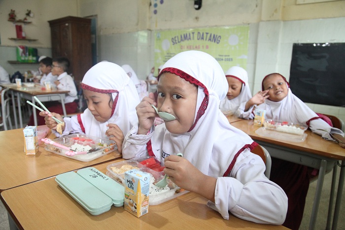 UJI COBA: Siswa di SD Taquma Surabaya menikmati menu Program Makan Bergizi Gratis, Senin (13/1/2025).