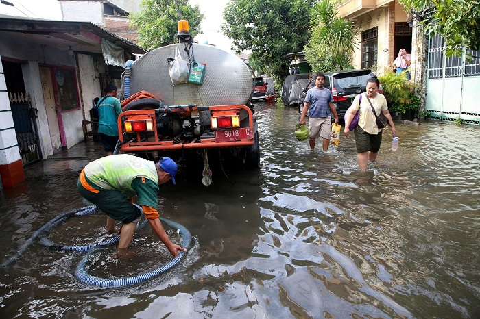 SIBUK: Petugas melakukan penanganan banjir di sejumlah titik di Kota Surabaya beberapa waktu lalu.
