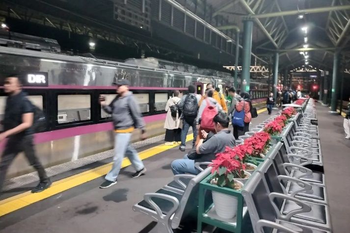 MENUNGGU: Sejumlah calon penumpang kereta api berjalan untuk menuju kereta yang ingin mereka tumpangi.