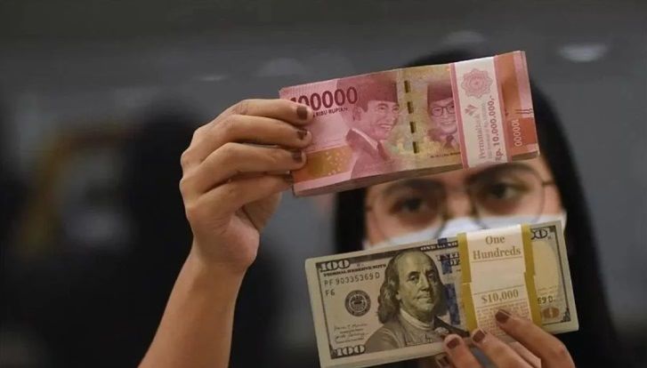 TERAWANG: Seorang karyawan money changer meneliti setiap lembaran rupiah yang akan ditukarkan dengan dolar Amerika Serikat.