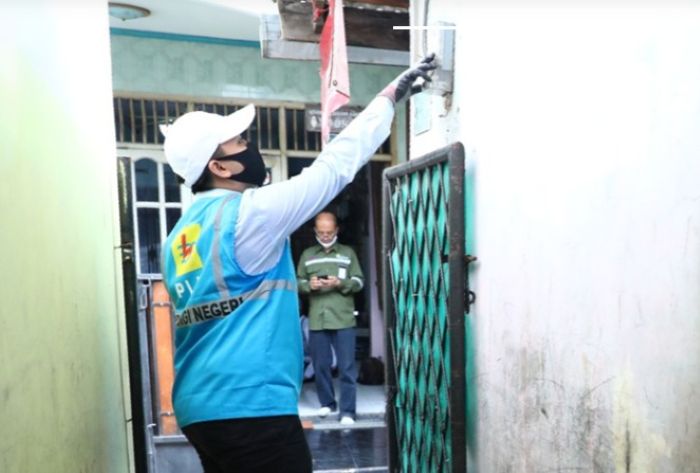 PERIKSA: Petugas PLN memeriksa meteran di salah satu pelanggan rumah tangga yang menikmati diskon tarif 50 persen di bulan Januari dan Februari 2025.